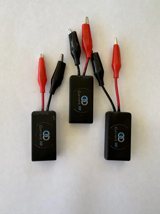 Three Current RF Mileage Booster modules with red and black clip leads